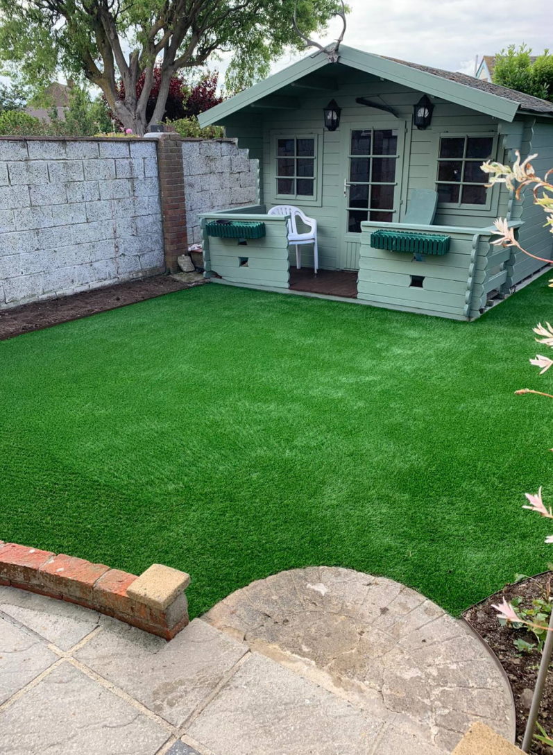 Artifical lawn with Sea-mint Green Summer house towards the end of the garden