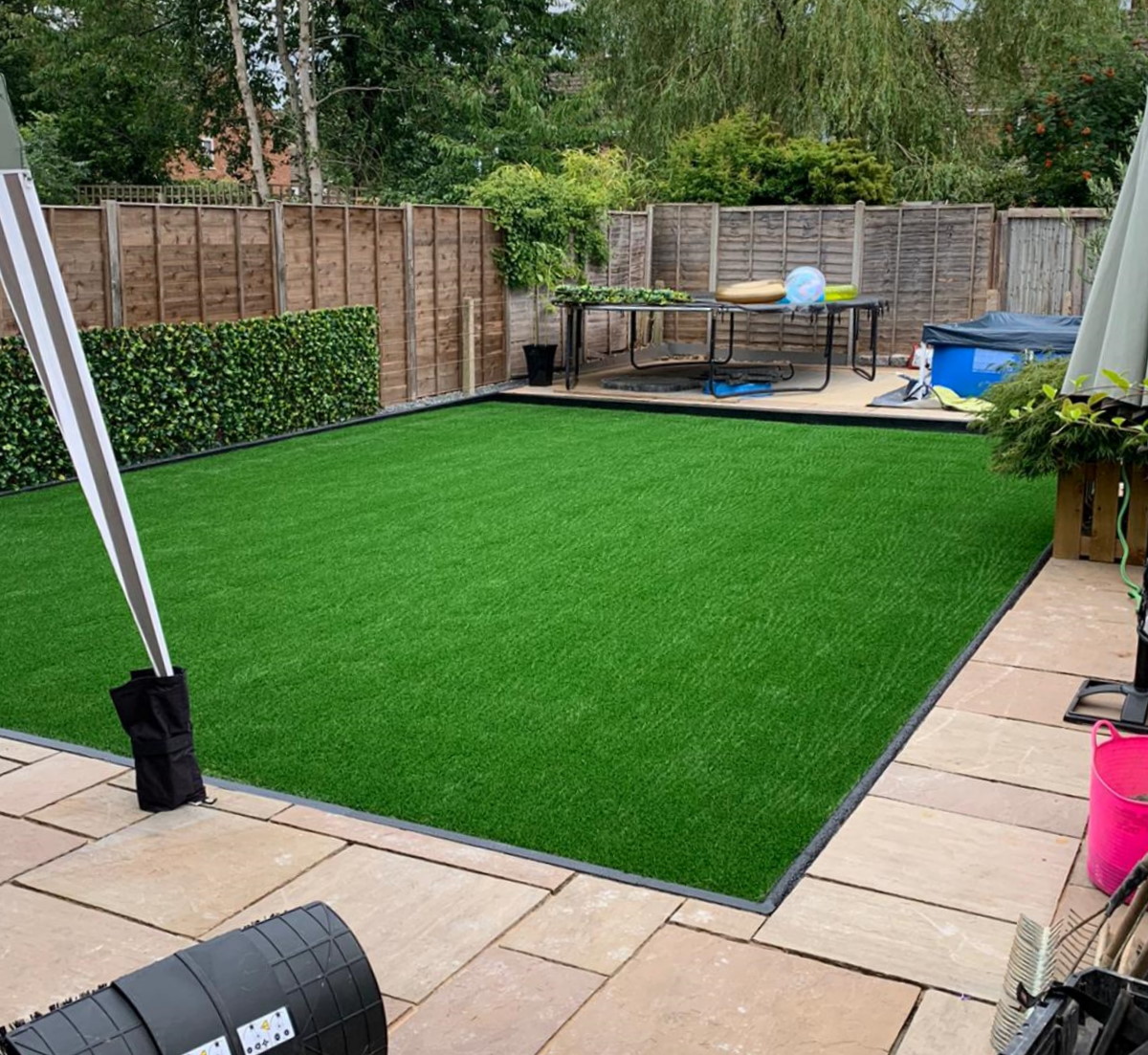 Artifical Lawn with patio surround and kids play equipment at the end