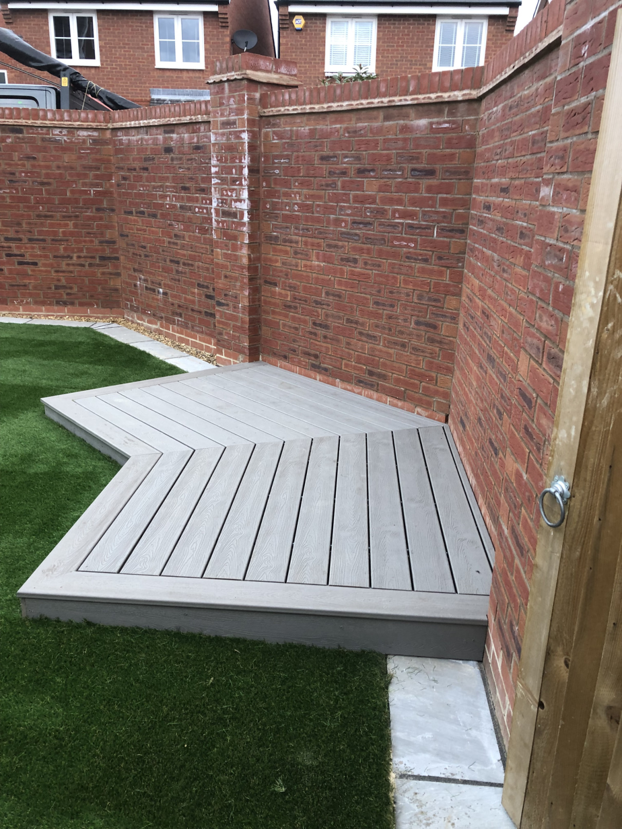 image of grey decking against a garden wall