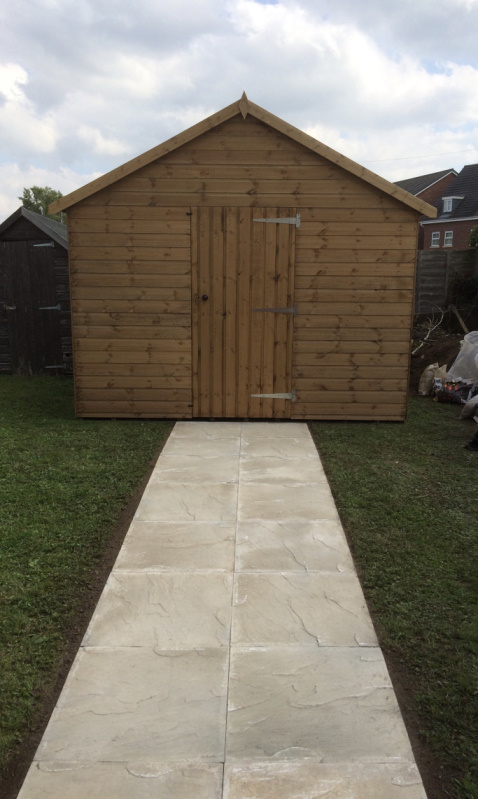 image of a garden shed with a long stone path